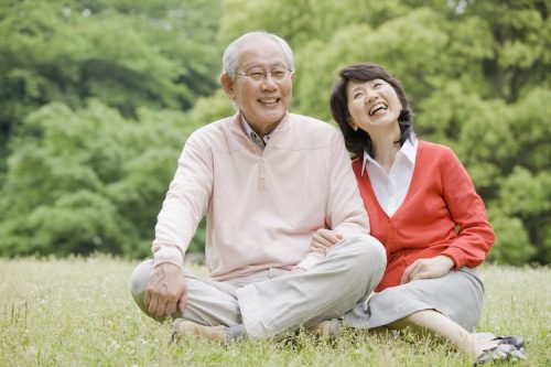 An old couple sitting on the grass in the Park, to have a conversation An old couple sitting on the grass in the Park, to have a conversation